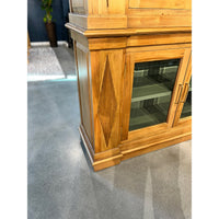 Base detail of bookcase with wood carving, showroom floor.
