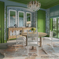 Dining table in room setting, green decor, chairs around.