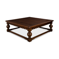 Side angle of rustic square coffee table, decorative legs visible.