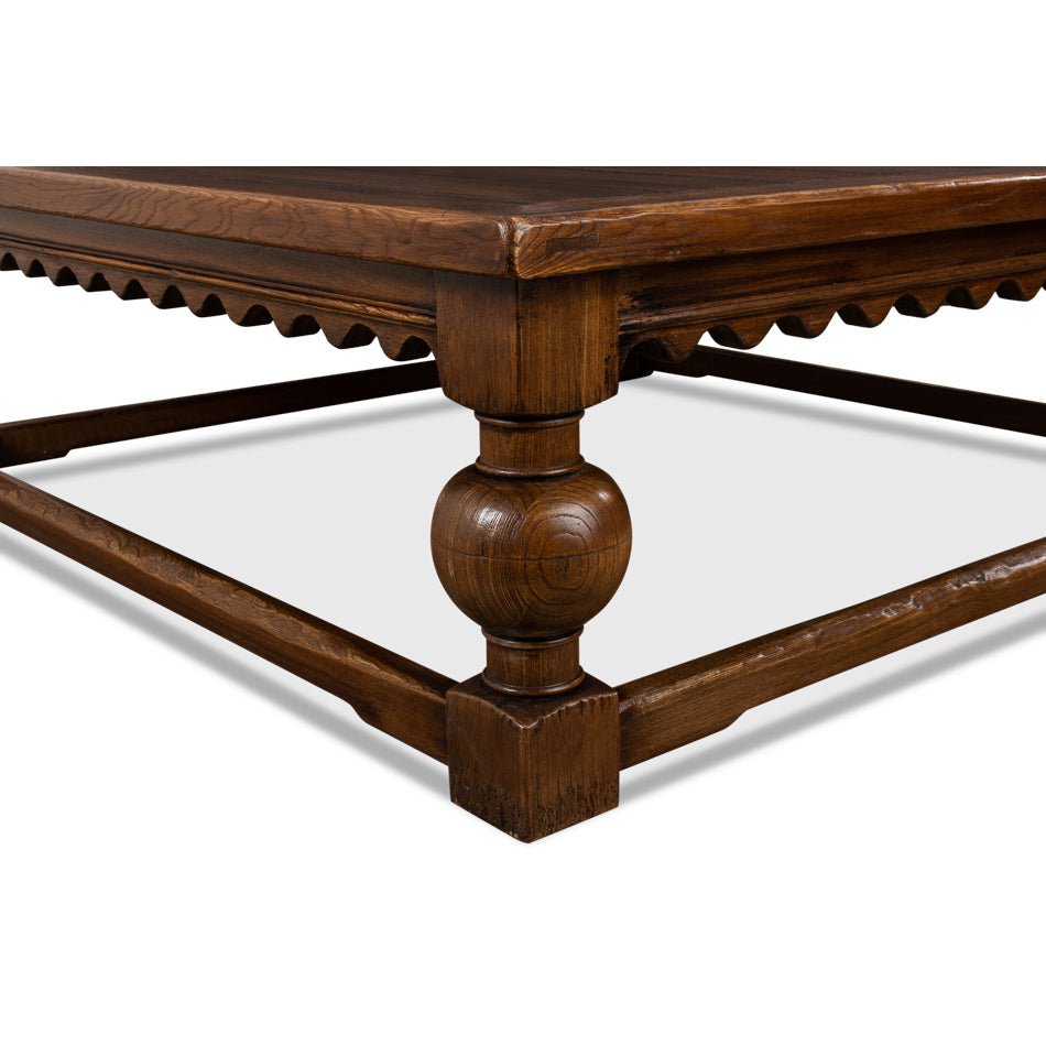 Corner detail of rustic square coffee table, ornate leg design.