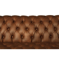 Chesterfield sofa tufted cushion, close-up on brown leather.