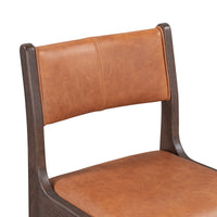 Close-up of the cognac leather backrest and seat within the dark ash wood frame