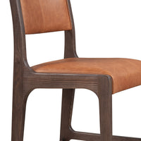 Detail of the cognac leather seat edge and dark ash wood grain along the side frame