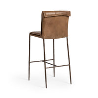 Three-quarter rear view of the slim-frame tan leather bar stool, showing the smooth back and rolled top edge