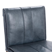 Close-up of the slim-frame blue leather bar stool’s rolled back, leather grain and vertical stitching