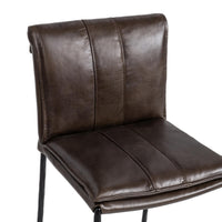 Close-up of the slim-frame dark brown leather bar stool’s rolled back, decorative stitching and padded seat