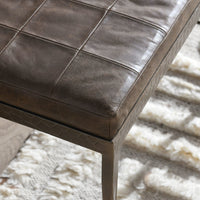 Close-up of the Cocoa Brown leather bench’s stitched seat corner and embossed iron frame