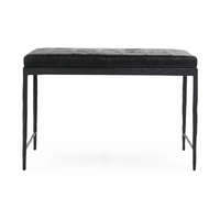 Front view of the Onyx Black leather bench showing its patchwork cushion, textured iron apron and tapered legs