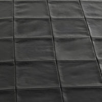 Close-up of the Onyx Black bench seat showing leather grain and square patchwork seams