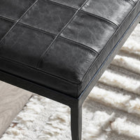 Close-up of the Onyx Black bench showing the leather cushion corner, stitched squares and textured iron frame