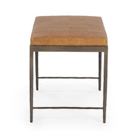 End view of the Sedona Brown leather bench showing its patchwork cushion and slim iron legs with crossbars