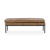 Front view of the tan leather bench showing its rounded cushion, two wraparound straps and black iron legs