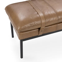 Close-up of the tan leather bench showing the stitched cushion edge and leather strap with metal fastener