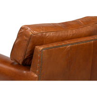 Brown leather club chair, close-up of backrest detail.
