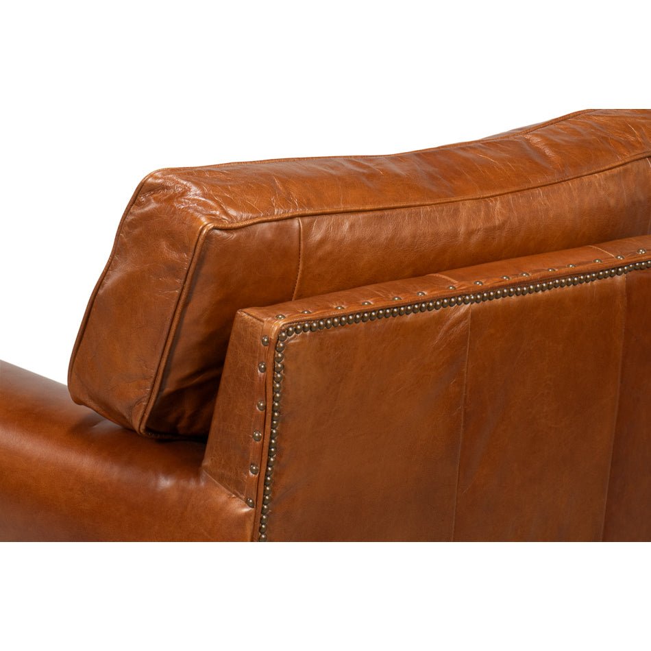 Brown leather club chair, close-up of backrest detail.