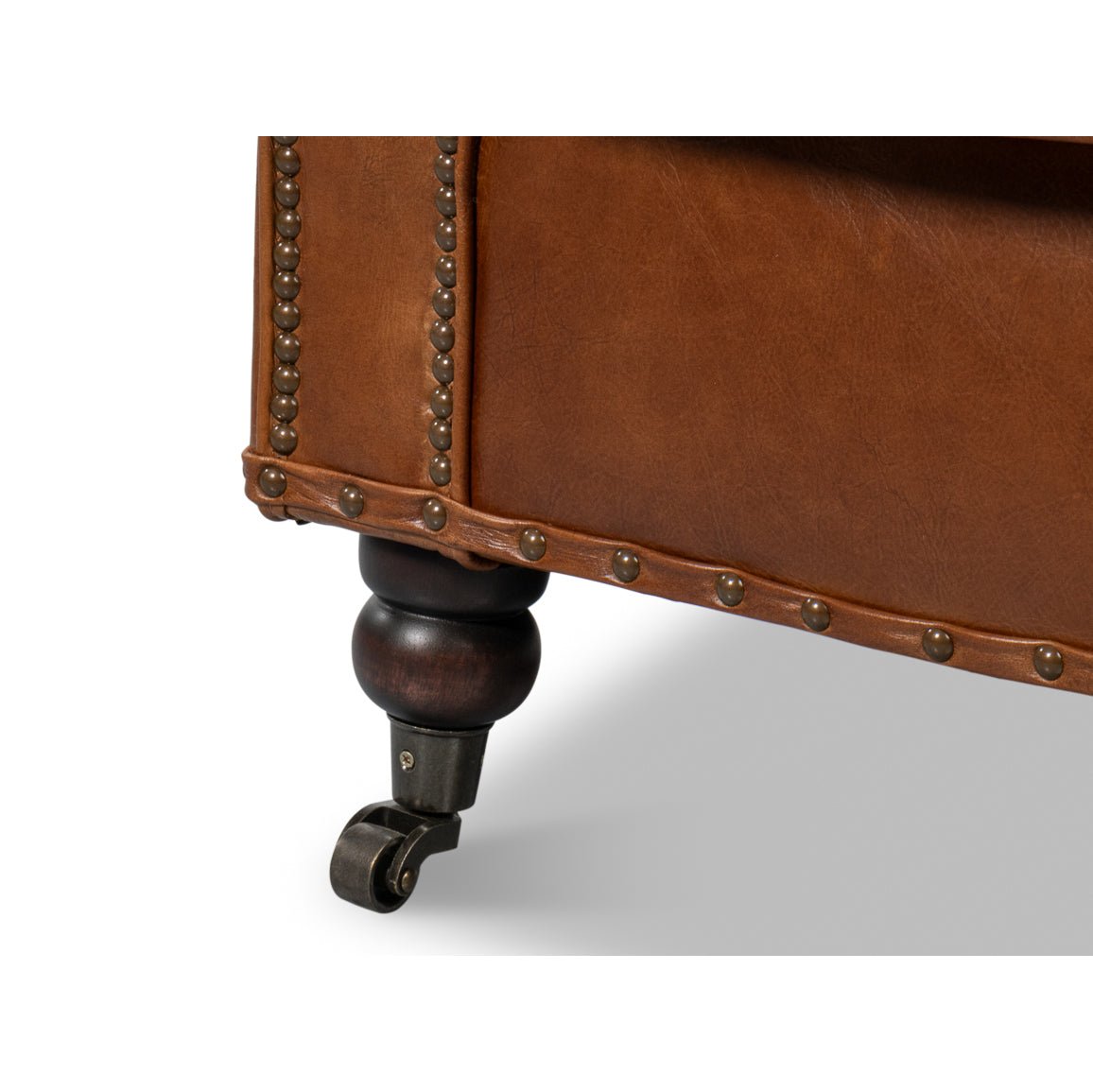 Brown leather club chair, close-up of leg with caster.