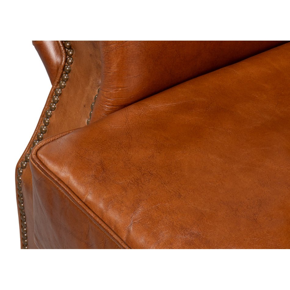 Brown leather club chair, close-up of seat and arm.