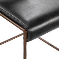 Close-up of the stitched black leather seat edge and hammered iron frame