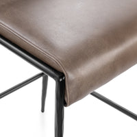 Close-up of the stitched front seat edge and dark hammered iron frame