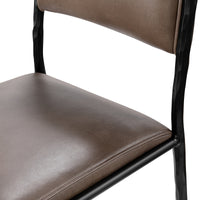 Detail of the taupe leather seat and back with the dark iron side supports