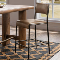 Taupe leather counter stool beside a wood counter table on a blue and tan rug