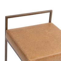 Close-up of the tan leather seat and open rectangular back rail on the low-back counter stool.