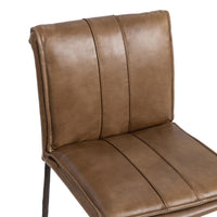 Close-up of the slim-frame tan leather counter stool’s rolled back, decorative stitching and padded seat