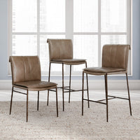 Tan slim-frame leather dining chair, counter stool and bar stool displayed together by a large window