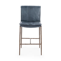 Front view of the slim-frame blue leather counter stool with a padded back, stitched seat and iron footrest