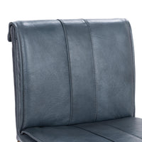 Close-up of the slim-frame blue leather counter stool’s rolled back, leather grain and vertical stitching