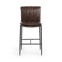 Front view of the slim-frame dark brown leather counter stool with a padded back, stitched seat and iron footrest