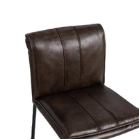 Close-up of the slim-frame dark brown leather counter stool’s rolled back, decorative stitching and padded seat