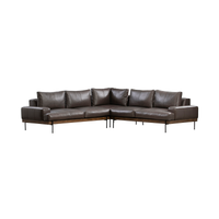 Front corner view of brown three-piece leather sectional with padded arms, a wood rail and slim dark legs