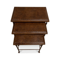 Top view of three stacked brown leather nesting tables.