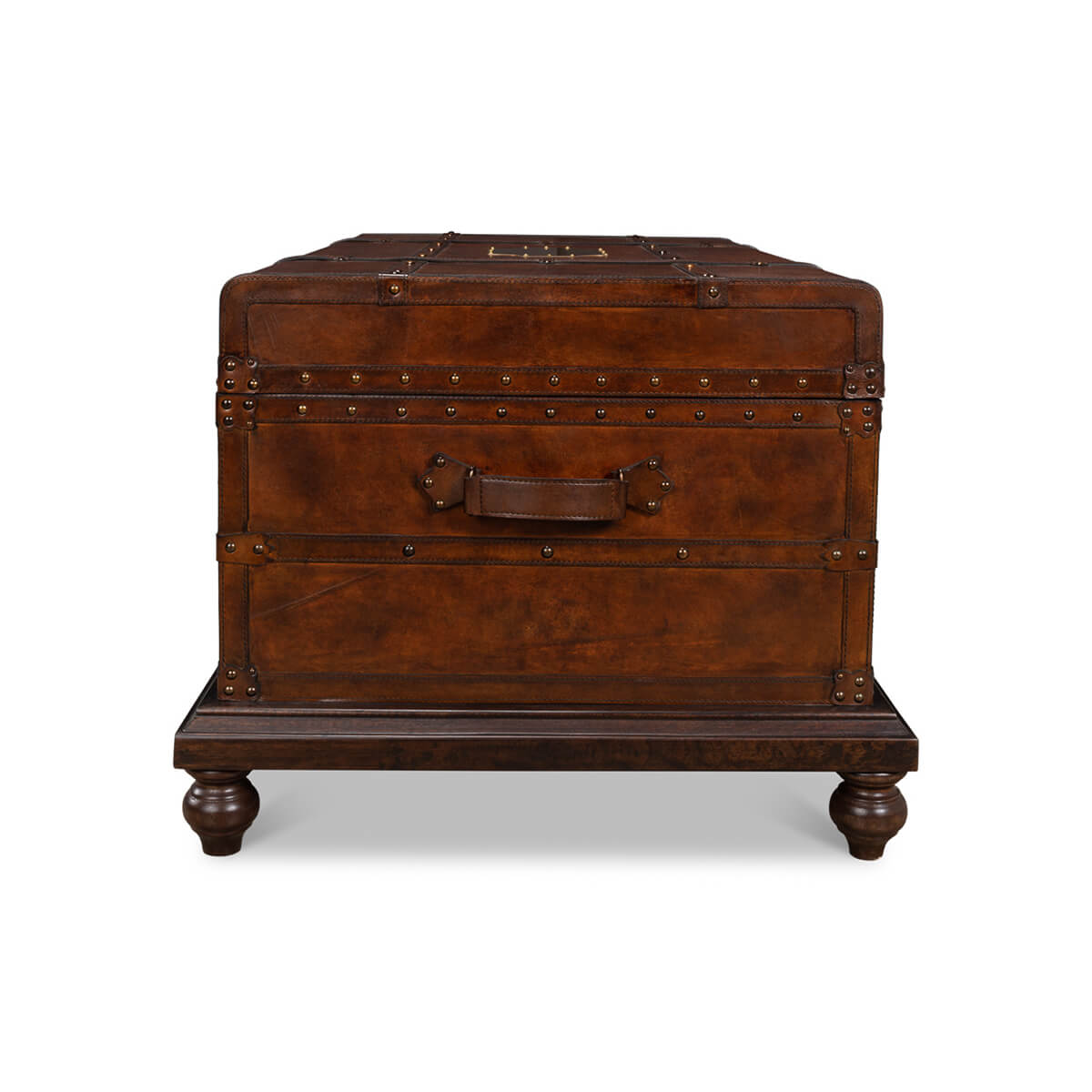 End view, leather trunk coffee table with decorative feet.