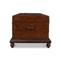 End view, leather trunk coffee table with decorative feet.