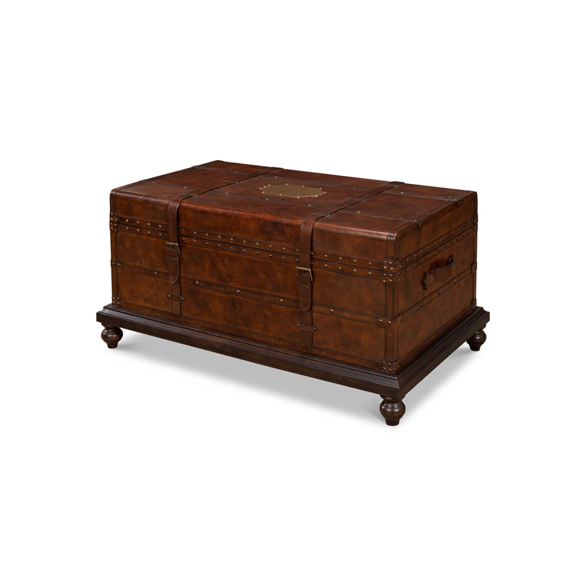 Brown leather trunk coffee table on turned legs, angled view.