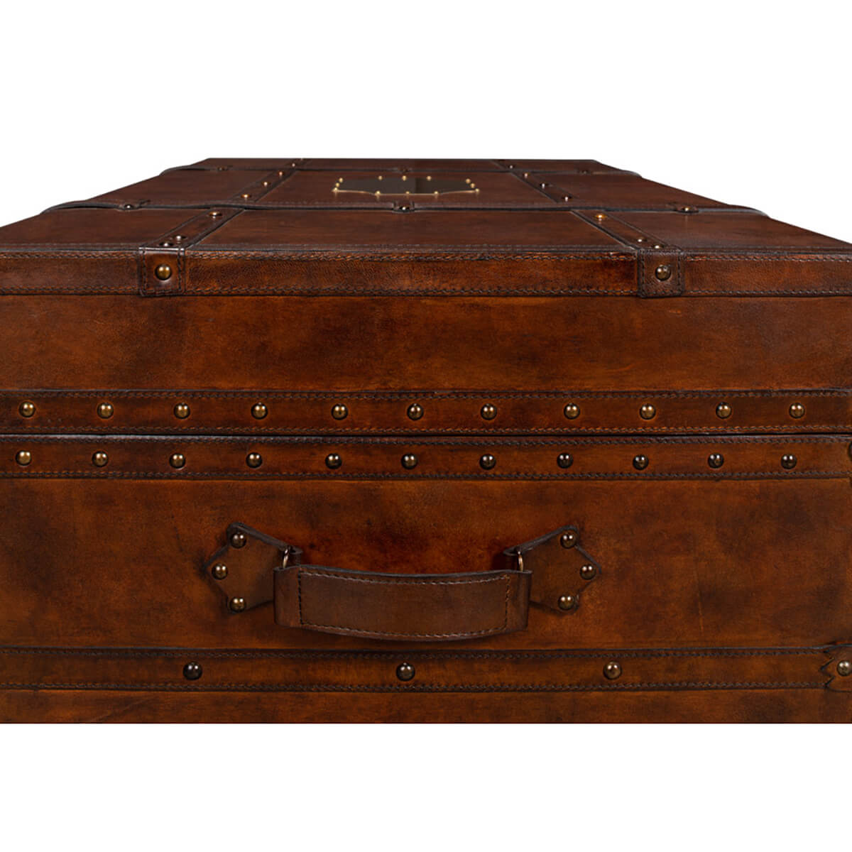 Handle and rivet close-up on leather trunk coffee table.