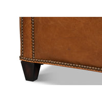 Light brown accent chair leg and base close-up.
