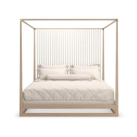 Front view of canopy bed, light wood, white pillows.