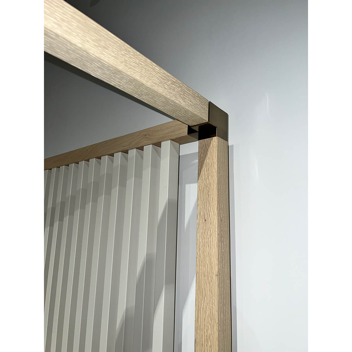 Corner detail of light mid-century canopy bed frame.