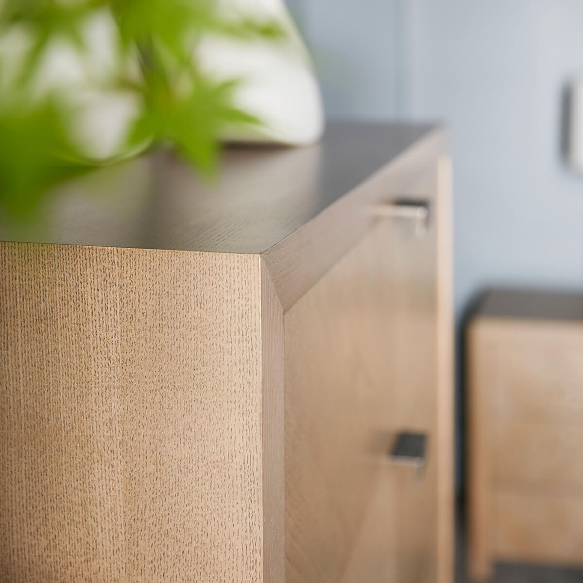 Close-up corner detail of modern nightstand in room.