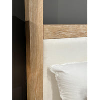 Close-up of light oak canopy bed frame detail.