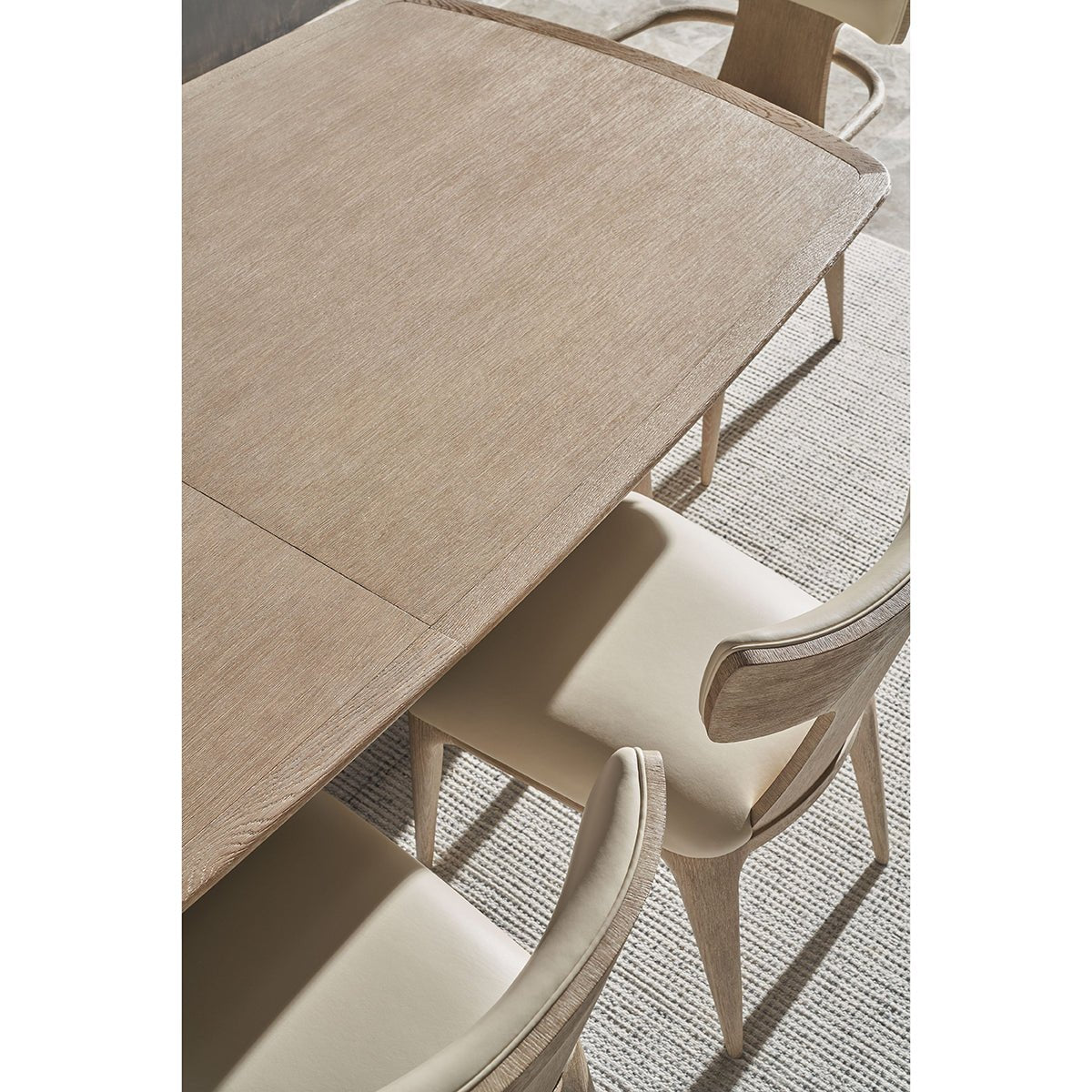 Close-up of light oak mid-century table surface and chairs.