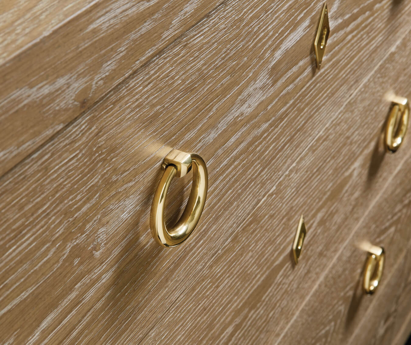 Close-up of handles on oak chest of drawers.