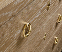 Close-up of handles on oak chest of drawers.