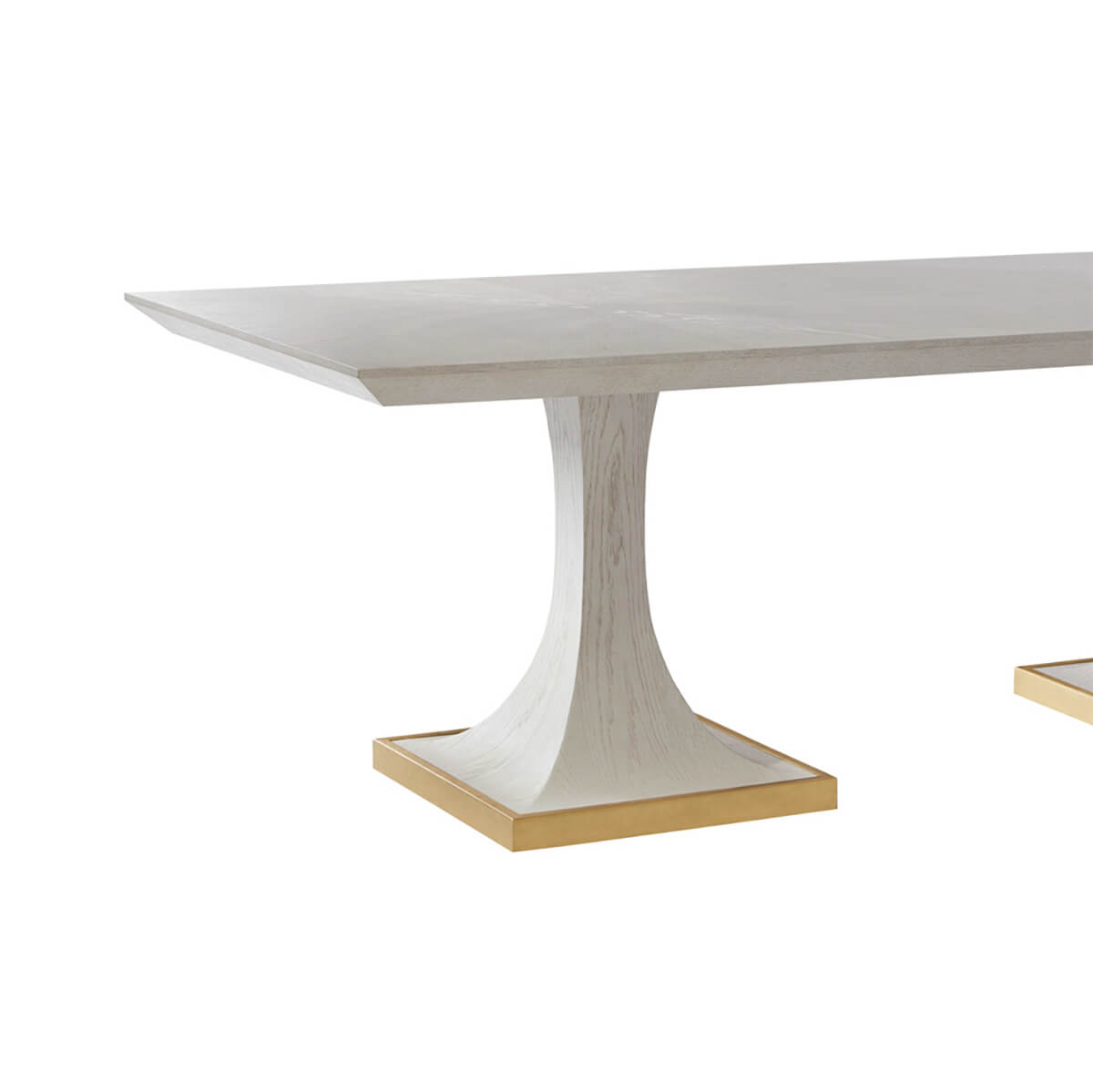 Side angle of white dining table on gold-trimmed bases.