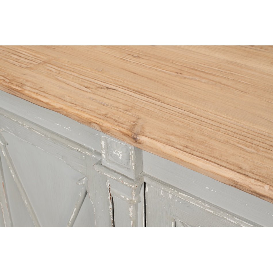Corner top detail of gray buffet with wooden surface.