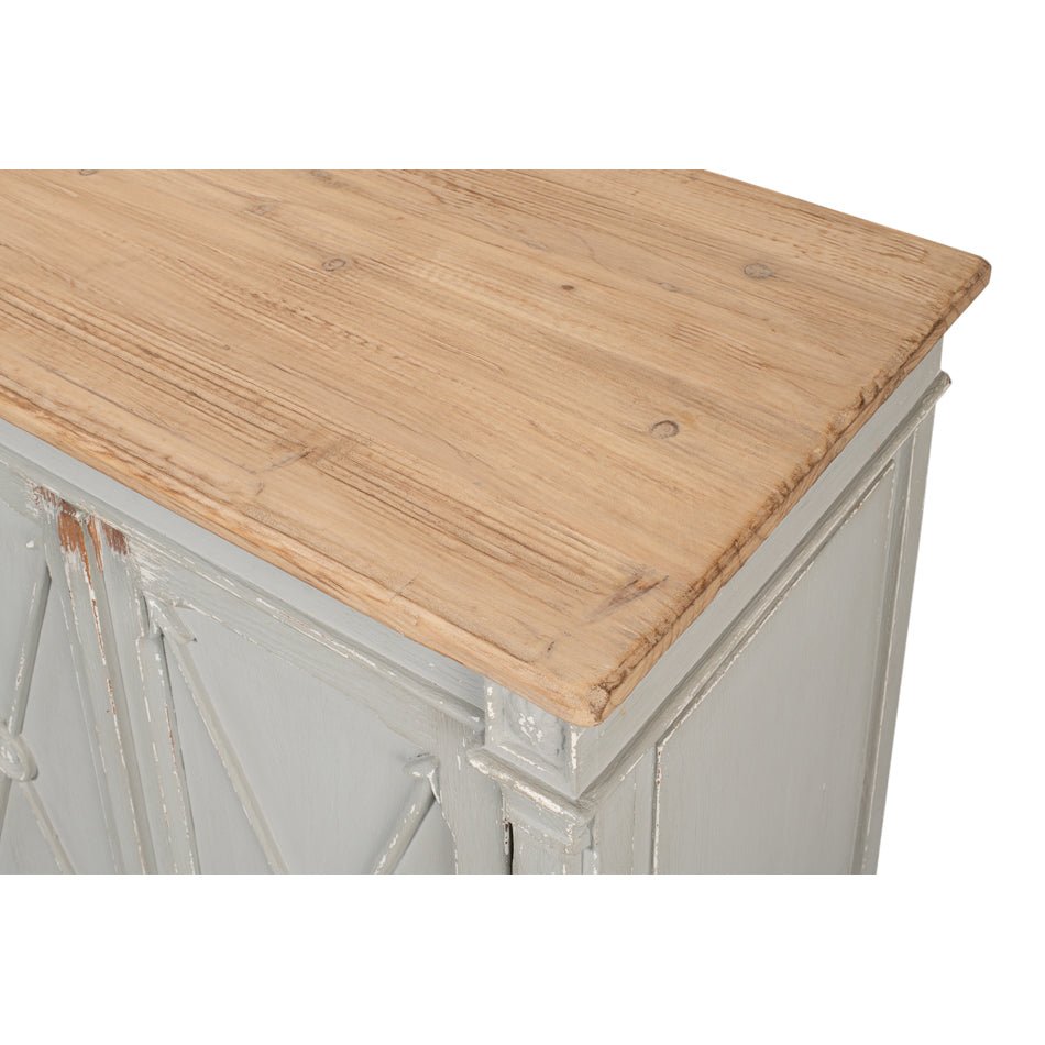 Close-up of wooden top of gray antique buffet.