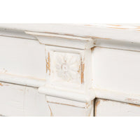 Decorative detail, white buffet, floral motif, close-up.